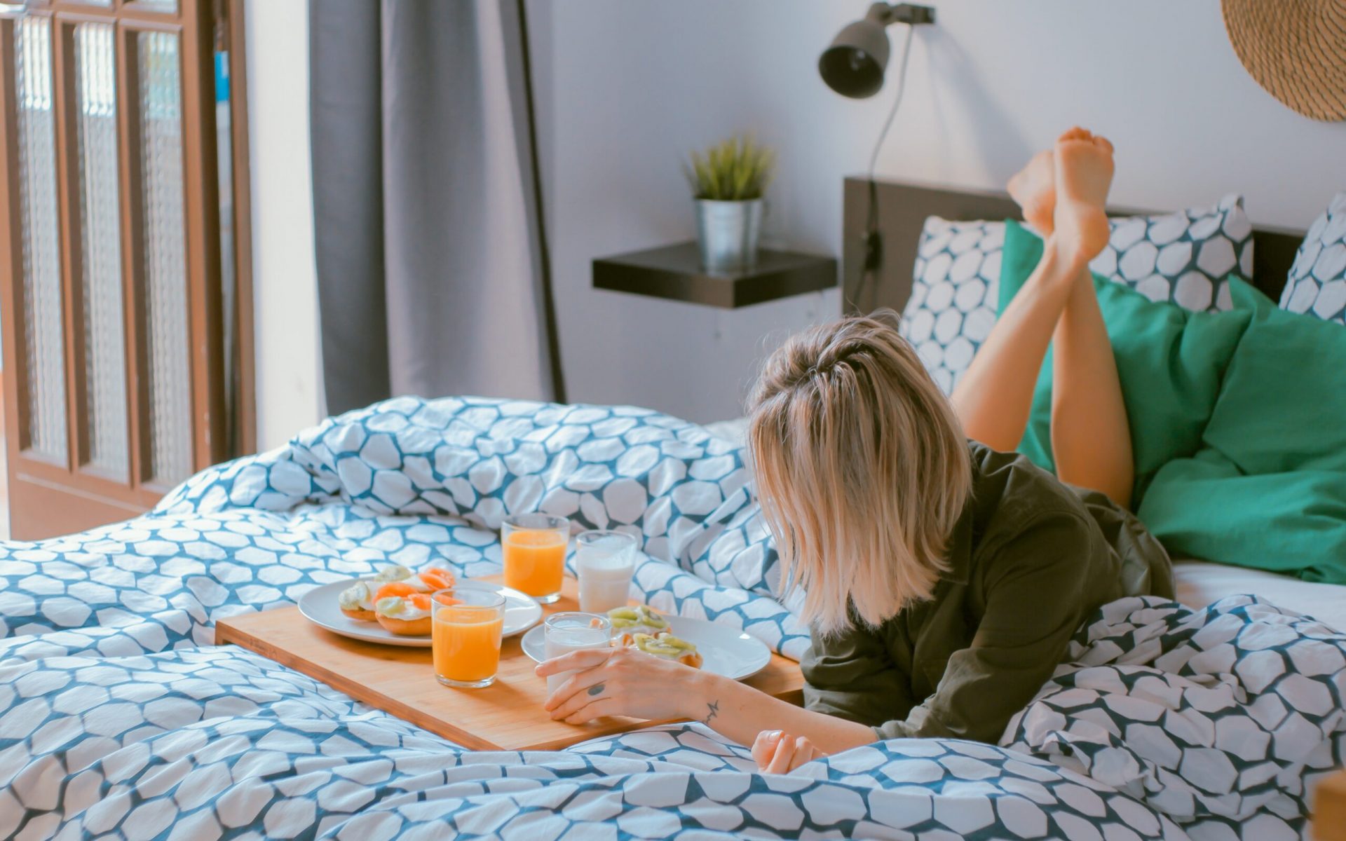 woman lying on bed white holding board