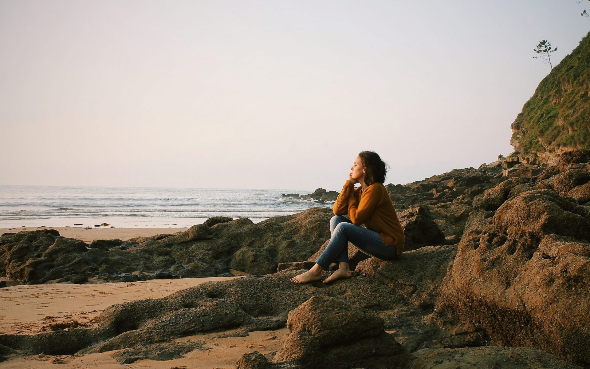 woman sitting near sea during daytime