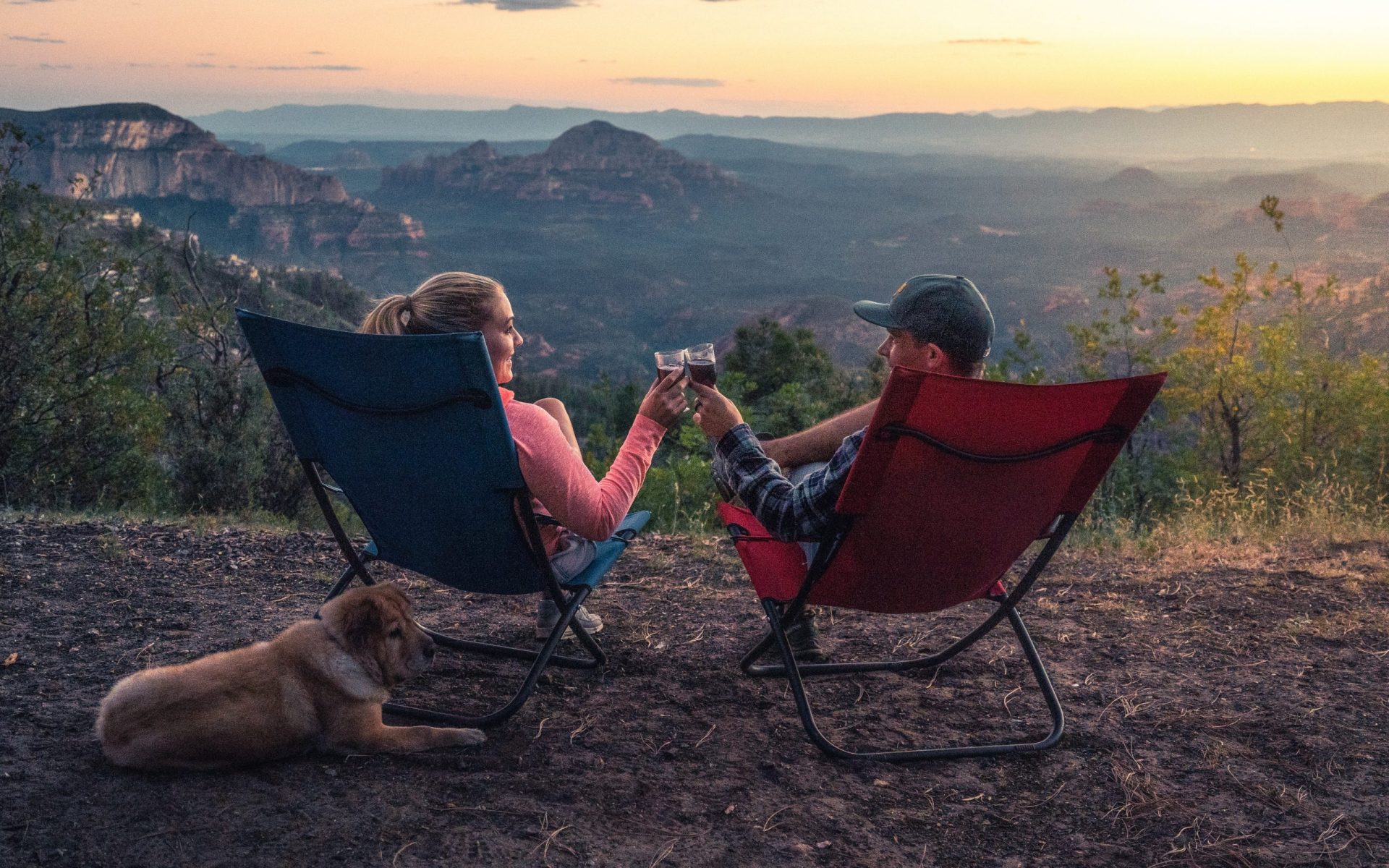 two person sitting on camping chairs while watching mountain